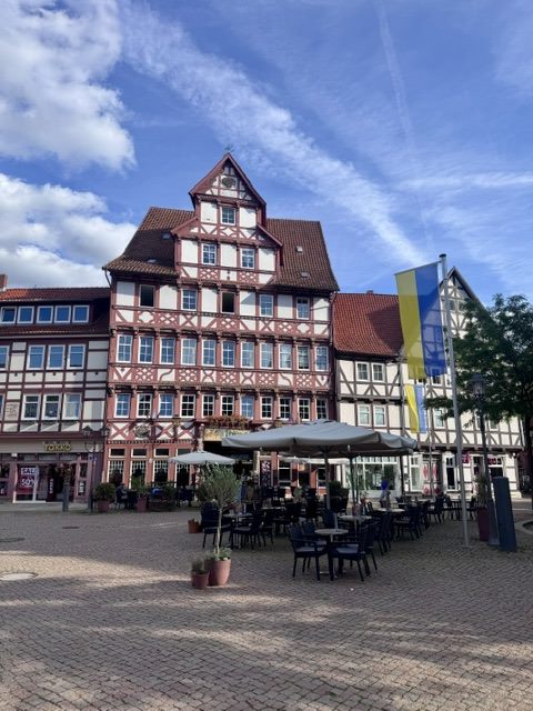 Marktplatz mit Fachwerkhaus und Café-Tischen