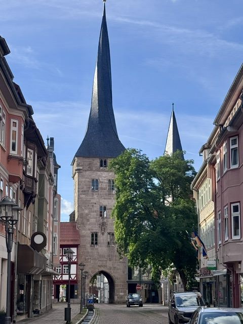Turm mit schiefem Turmhelm über einer Altstadtgasse